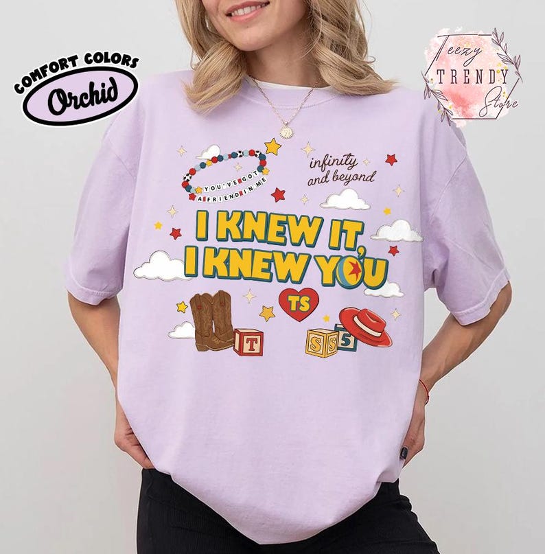 Puede incluir: Una camiseta de manga corta de color morado claro con un estampado gr&aacute;fico que incluye el texto I KNEW IT, I KNEW YOU, infinity and beyond y YOU'VE GOT A FRIEND IN ME. El dise&ntilde;o incluye botas vaqueras marrones, un sombrero rojo y estrellas.