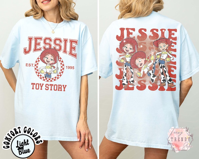 May include: Light blue t-shirt featuring the character Jessie from Toy Story. The front design includes the name "JESSIE" in red, with a cartoon image of Jessie and the text "TOY STORY". The back of the shirt repeats the name "JESSIE" with multiple images of the character.