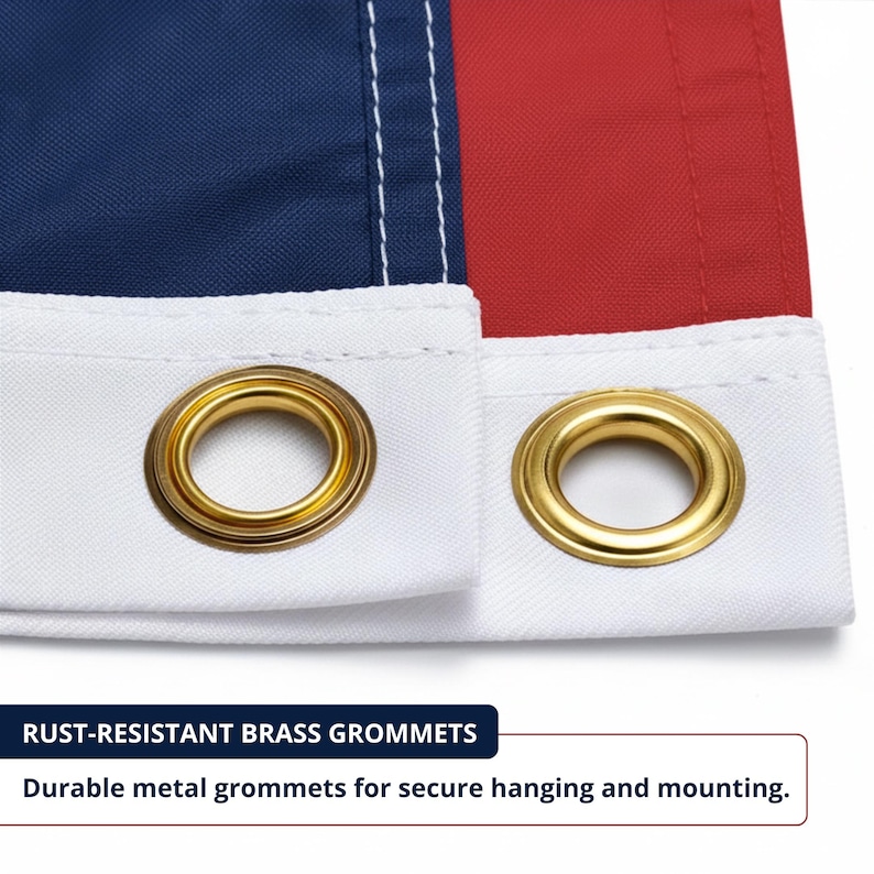 May include: Close-up of a flag with blue, white, and red sections. The flag has rust-resistant brass grommets for secure hanging. The white border features two gold-coloured grommets. Text reads "Rust-Resistant Brass Grommets" and "Durable metal grommets for secure hanging and mounting."