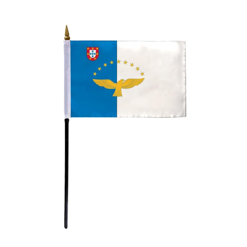 Puede incluir: Una peque&ntilde;a bandera de escritorio de las Azores, una regi&oacute;n aut&oacute;noma portuguesa. La bandera presenta un campo azul con el escudo de armas portugu&eacute;s en la esquina superior del asta y un campo blanco con un p&aacute;jaro dorado volando sobre una media luna de cinco estrellas doradas.