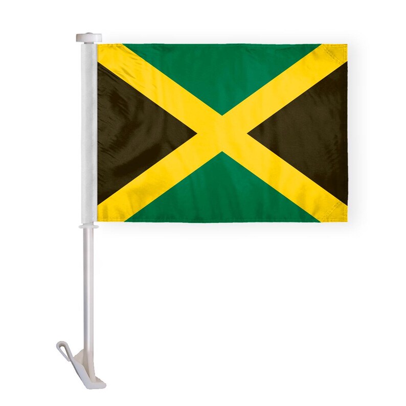 Puede incluir: Una peque&ntilde;a bandera jamaicana, con una cruz diagonal amarilla sobre un fondo verde y negro. La bandera est&aacute; montada en un m&aacute;stil de pl&aacute;stico blanco, dise&ntilde;ado para fijarse a la ventana de un coche. El dise&ntilde;o es un s&iacute;mbolo nacional.