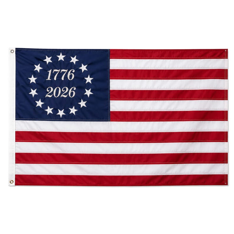 May include: A rectangular flag with a blue canton featuring a circle of white stars, the numbers "1776" and "2026" in white. The flag has alternating red and white horizontal stripes.