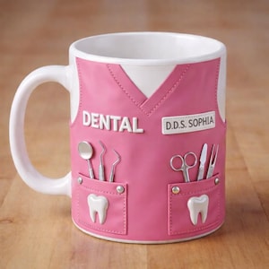May include: A white ceramic mug with a pink dental scrubs design. The mug features the word "DENTAL" and "D.D.S. SOPHIA" in white lettering. It includes illustrations of dental tools and teeth.