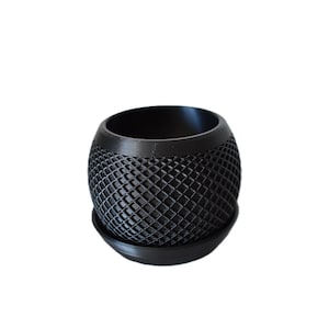 May include: A black, spherical planter with a lattice design. The planter sits on a matching saucer. The open top reveals the interior. This decorative item is suitable for small plants and succulents.