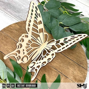 May include: A laser-cut wooden butterfly cutout featuring intricate, open-work wing patterns. The light-colored wood butterfly is positioned on a circular wooden base, with green eucalyptus leaves visible around the edges of the cutout.