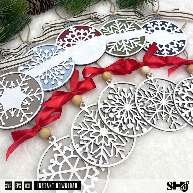 May include: A collection of circular snowflake ornaments featuring various designs. Some ornaments are solid with coloured backgrounds and white snowflake cutouts, while others are open-work white snowflake frames accented with red ribbons and wooden beads.