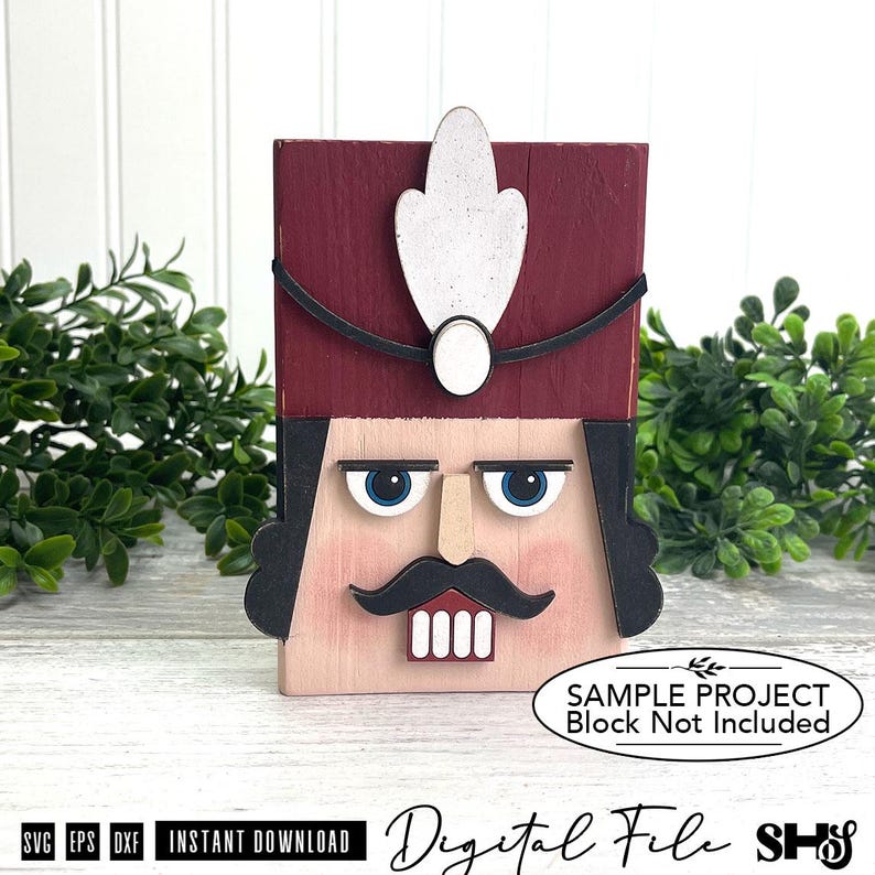 Puede incluir: Un bloque de madera de cascanueces con un sombrero rojo oscuro con una pluma blanca, cabello negro, ojos azules, nariz beige, bigote negro y dientes blancos. El bloque incluye el texto: SAMPLE PROJECT Block Not Included.