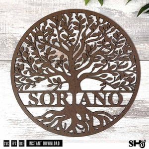 May include: A circular brown wooden wall hanging featuring a laser-cut tree of life design with intricate branches and roots. The name SORIANO is prominently displayed in capital letters across the center of the tree trunk within the circle.