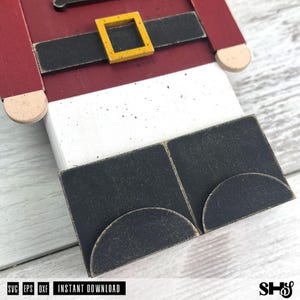 May include: A wooden nutcracker cutout featuring a red jacket, a black belt with a yellow square buckle, white trousers, and black boots with rounded toes. The design includes text at the bottom reading SVG EPS DXF INSTANT DOWNLOAD.