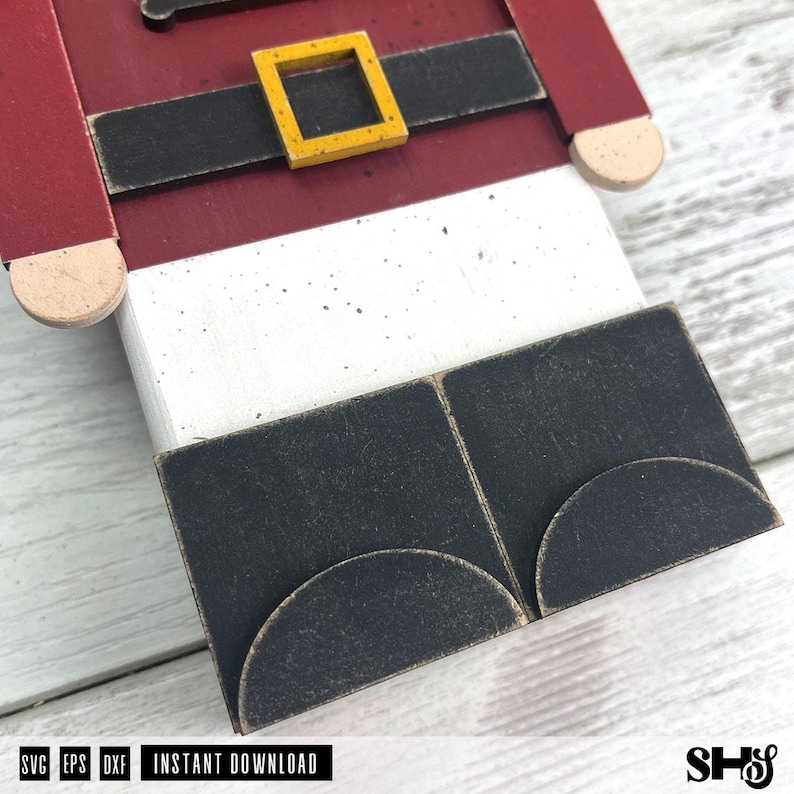 May include: A wooden nutcracker cutout featuring a red jacket, a black belt with a yellow square buckle, white trousers, and black boots with rounded toes. The design includes text at the bottom reading SVG EPS DXF INSTANT DOWNLOAD.
