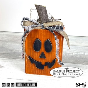 May include: A wooden block pumpkin decoration with a painted orange finish, black facial features, and a natural wood stem. It is adorned with a burlap and black-and-white plaid fabric bow. The image includes text stating Sample Project Block Not Included.