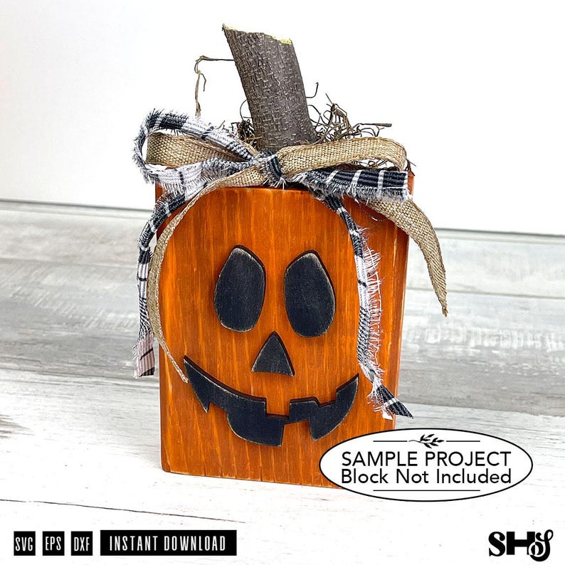 May include: A wooden block pumpkin decoration with a painted orange finish, black facial features, and a natural wood stem. It is adorned with a burlap and black-and-white plaid fabric bow. The image includes text stating Sample Project Block Not Included.