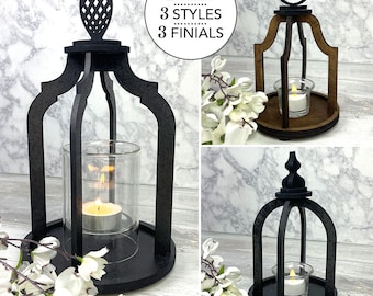 May include: A black wooden lantern with a glass candle holder, shown in multiple styles. The lantern has a decorative top and a round base. The image also includes the text "2 Sizes, 3 Styles, 3 Finials" and "SVG EPS DXF INSTANT DOWNLOAD".