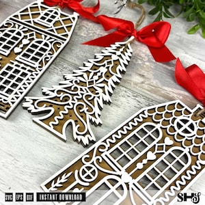 Puede incluir: Adornos navide&ntilde;os de madera con forma de casa y &aacute;rbol de Navidad. Los adornos est&aacute;n superpuestos con una capa superior blanca y una base marr&oacute;n. Cada adorno tiene una cinta roja para colgar. La imagen tambi&eacute;n incluye el texto "SVG EPS DXF INSTANT DOWNLOAD".