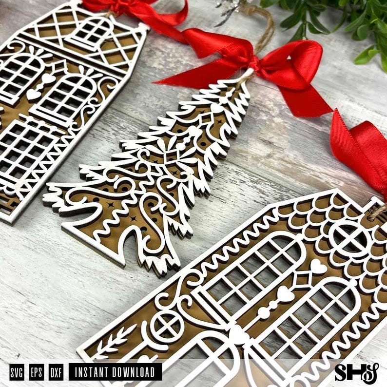 Puede incluir: Adornos navide&ntilde;os de madera con forma de casa y &aacute;rbol de Navidad. Los adornos est&aacute;n superpuestos con una capa superior blanca y una base marr&oacute;n. Cada adorno tiene una cinta roja para colgar. La imagen tambi&eacute;n incluye el texto "SVG EPS DXF INSTANT DOWNLOAD".