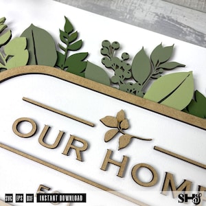 May include: A wooden sign with the words "Our Home" in brown lettering. The sign is decorated with green leaves and flowers.