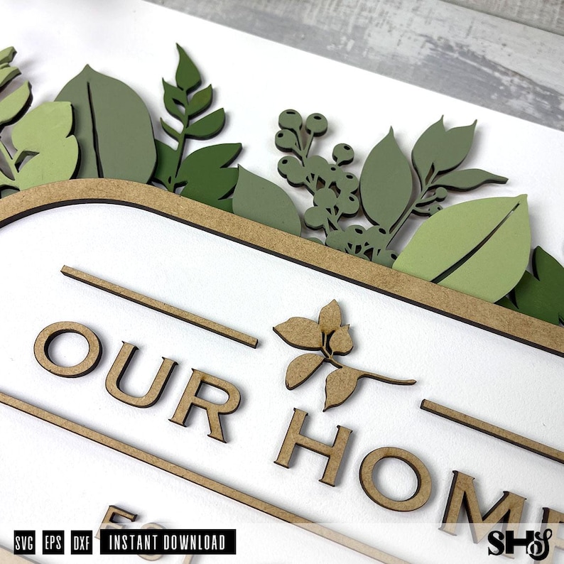 May include: A wooden sign with the words "Our Home" in brown lettering. The sign is decorated with green leaves and flowers.
