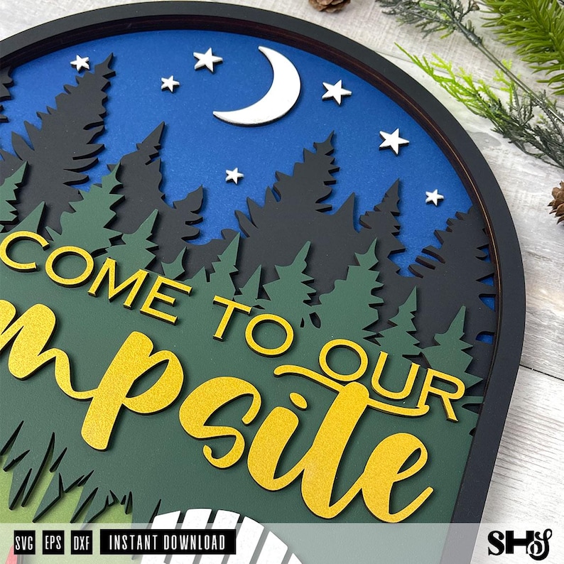 May include: A layered circular wall sign featuring a blue night sky with a white crescent moon and stars above black and green pine tree silhouettes. The text COME TO OUR campsite is displayed in large yellow letters over the forest scene.