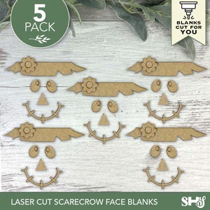 Puede incluir: Un conjunto de cinco plantillas de caras de espantap&aacute;jaros cortadas con l&aacute;ser. Cada cara incluye un sombrero con flores, ojos ovalados, una nariz triangular y una boca sonriente. El texto "5 PACK" est&aacute; en un c&iacute;rculo verde. Las palabras "LASER CUT SCARECROW FACE BLANKS" est&aacute;n en la parte inferior.