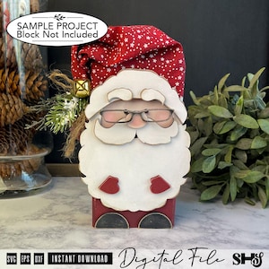 May include: A decorative Santa Claus figure featuring a red fabric hat with white stars, a large white wooden beard, wire-rimmed glasses, and small red mittens. The figure is accented with a gold bell and green pine sprigs on the side.