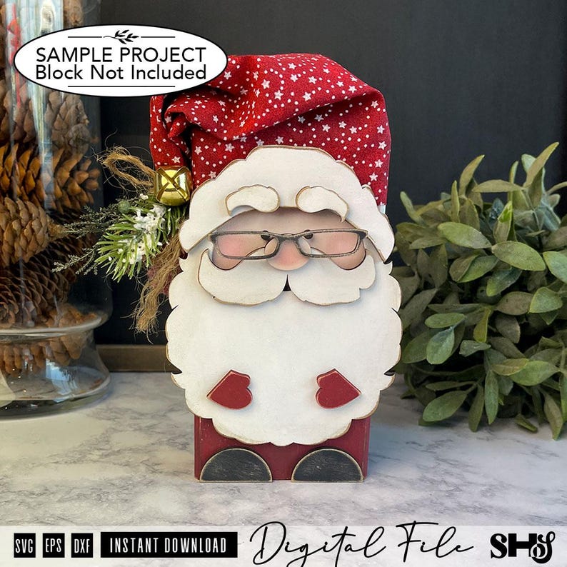 May include: A decorative Santa Claus figure featuring a red fabric hat with white stars, a large white wooden beard, wire-rimmed glasses, and small red mittens. The figure is accented with a gold bell and green pine sprigs on the side.