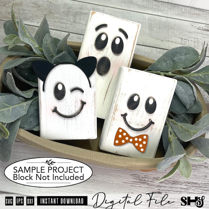 May include: Three rectangular white wooden blocks featuring black ghost faces. One block has black cat ears, one has a surprised expression, and one features an orange polka dot bow tie. The image includes text stating SAMPLE PROJECT Block Not Included.
