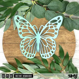 May include: A light mint green butterfly cutout with intricate, symmetrical wing patterns featuring various circular and elongated open spaces. The butterfly is positioned centrally, showcasing a flat, smooth surface and clean, precise edges.