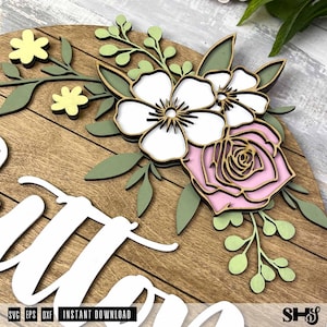 Puede incluir: Un letrero de pared circular de madera con recortes en capas de flores blancas y rosas, hojas verdes y peque&ntilde;as flores amarillas. El letrero incluye letras cursivas blancas y el texto SVG, EPS, DXF, INSTANT DOWNLOAD y SHS.