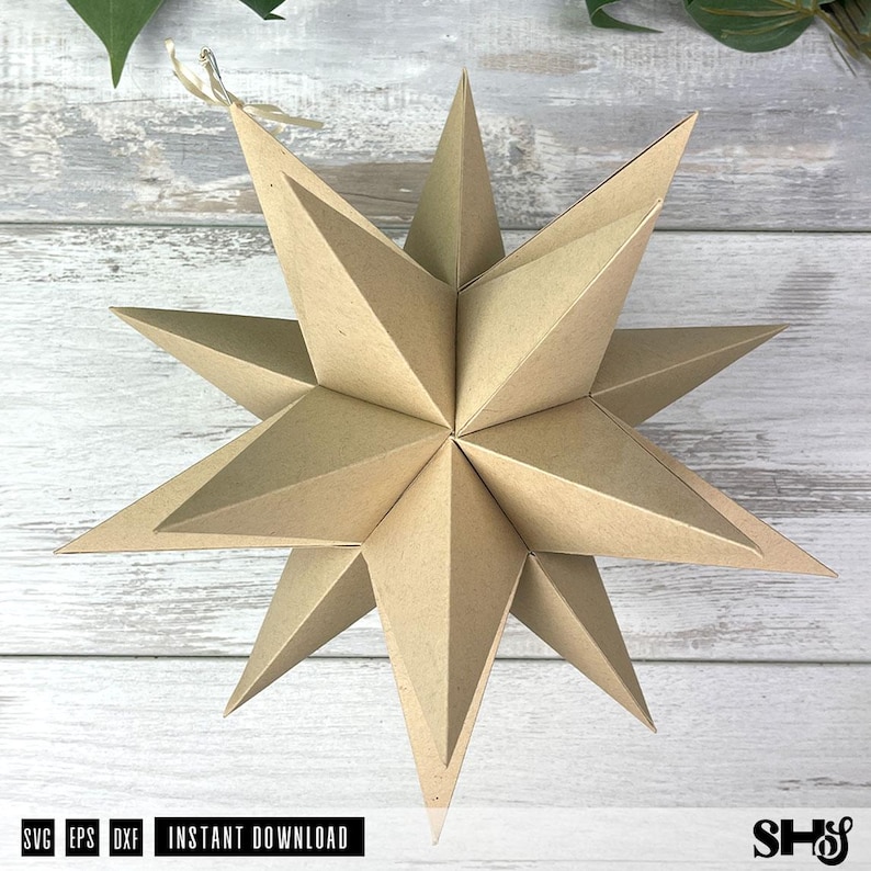 May include: A three-dimensional star ornament constructed from light brown kraft paper with multiple pointed tips. The geometric structure features sharp, folded edges and a small string loop attached to the top point for hanging purposes.