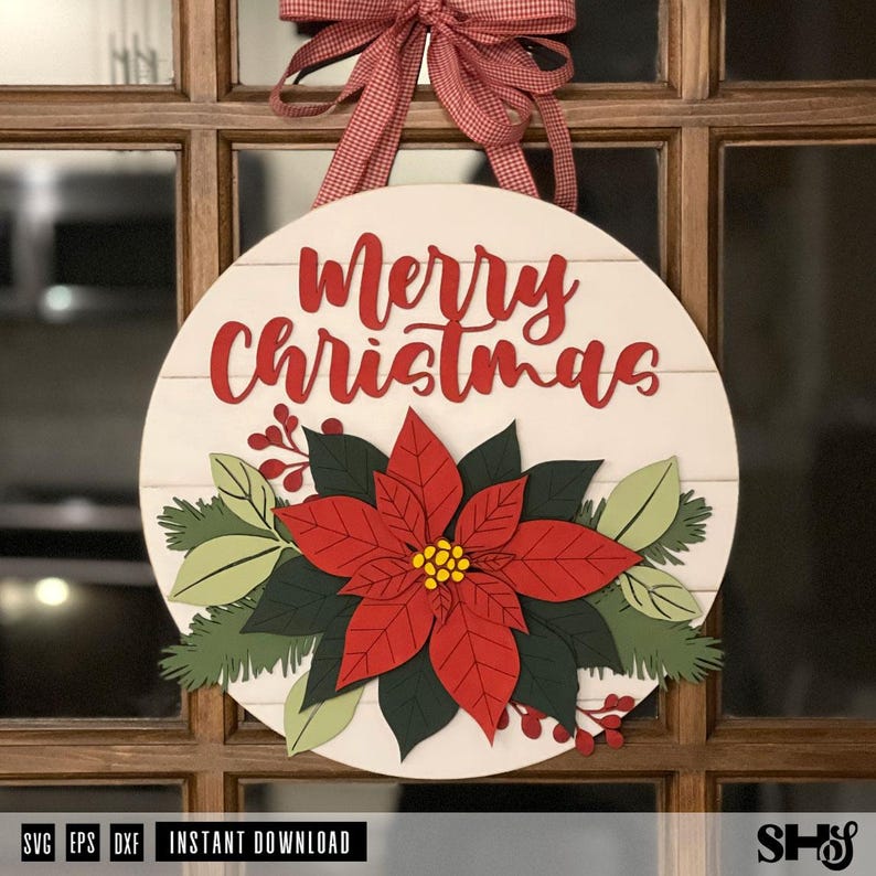 K&ouml;nnte beinhalten: Ein rundes wei&szlig;es Holzschild mit horizontalen Plankenlinien und dem roten Schriftzug Merry Christmas. Das Schild ist mit einer geschichteten 3D-Weihnachtssternbl&uuml;te in Rot, Dunkelgr&uuml;n und Hellgr&uuml;n verziert und mit einer roten Vichy-Schleife versehen.