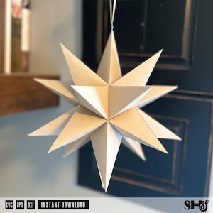 May include: A three-dimensional star ornament constructed from light beige paper with multiple sharp, pointed triangular facets. The geometric structure is suspended by a thin white string, featuring a complex, symmetrical design with many radiating points.