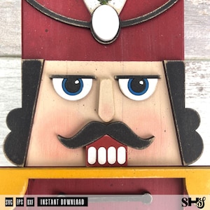 May include: A wooden nutcracker face cutout featuring a deep red hat with a white oval emblem, black hair, blue eyes, a prominent nose, a black moustache, and white teeth. The design includes a yellow collar and the text SVG EPS DXF INSTANT DOWNLOAD.