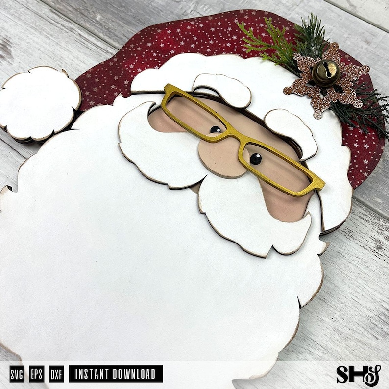 K&ouml;nnte beinhalten: Ein mehrschichtiger Holzausschnitt eines Weihnachtsmann-Gesichts mit einem gro&szlig;en wei&szlig;en Bart, einer roten M&uuml;tze mit wei&szlig;em Sternenmuster, einer goldfarbenen Brille und einem dekorativen braunen Glitzer-Schneeflocken-Akzent mit einer kleinen Metallglocke.