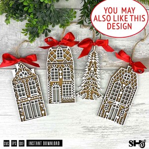 May include: Four laser-cut wooden ornaments featuring two house designs and one Christmas tree design, each layered with white intricate details and topped with a bright red satin ribbon bow for hanging, displayed on a light wood surface.