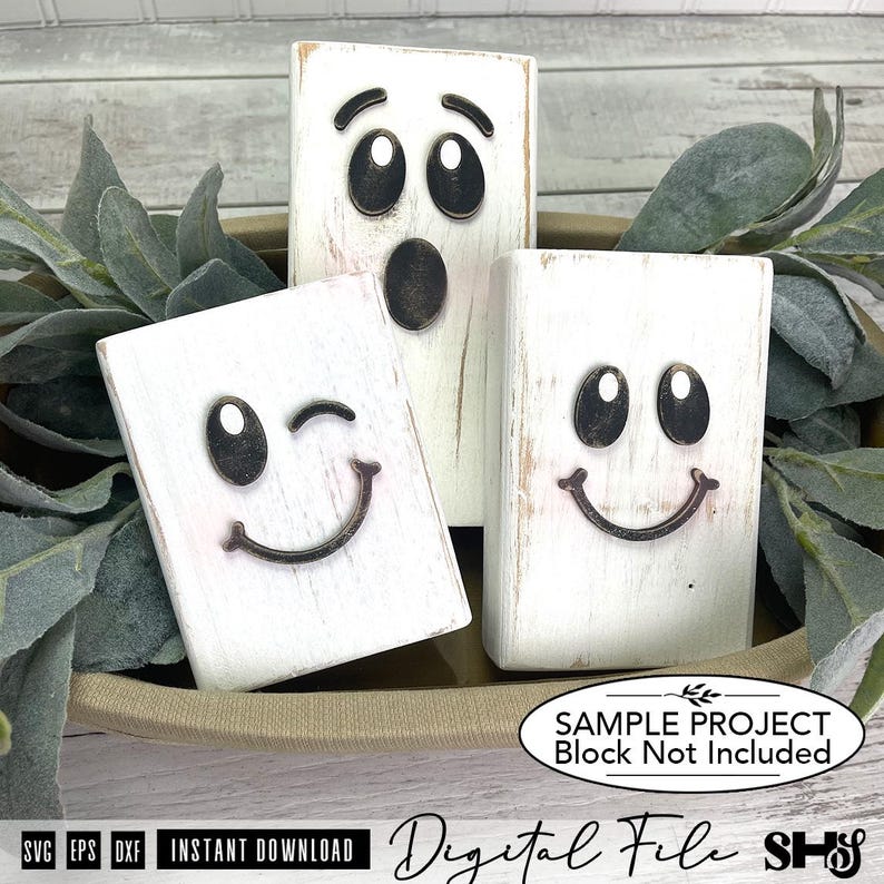 May include: Three rectangular white wooden blocks with distressed finishes, each featuring a dark metal ghost face. One block shows a surprised expression, while the other two display smiling faces, with one of those winking. Text reads: SAMPLE PROJECT Block Not Included.