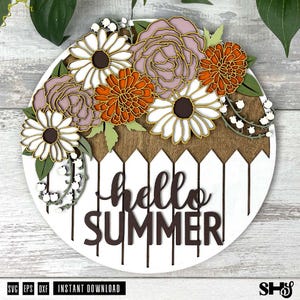 May include: A round wooden sign with a white background and a brown picket fence design. The sign says "hello summer" in black lettering. The top of the sign is decorated with a variety of flowers, including white daisies, pink roses, and orange and brown chrysanthemums.