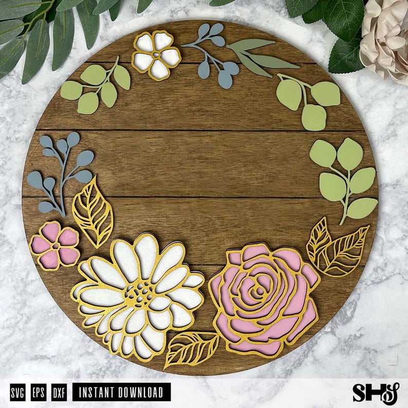 Op de afbeelding: Een rond houten bord met een bloemmotief. Het bord heeft een lichtbruine houten achtergrond met een witte madeliefje, een roze roos en groene bladeren. Het bord heeft de tekst "INSTANT DOWNLOAD" onderaan.