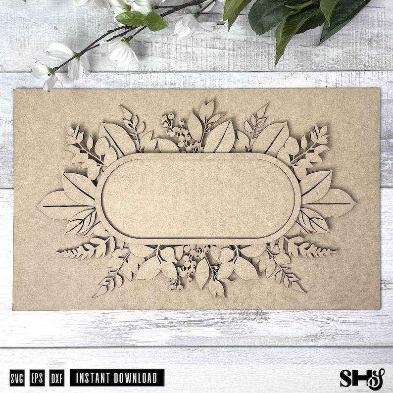 May include: A wooden cutout of a floral wreath with a blank oval in the center. The wreath is made of leaves and flowers, and the oval is perfect for adding a personalized message.