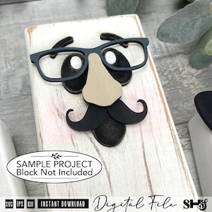 May include: A rectangular white wooden block featuring a layered cutout design of a face with black glasses, a tan nose, and a black mustache. An oval label on the block reads: SAMPLE PROJECT Block Not Included. Text at the bottom reads: Digital File.