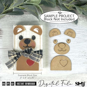 May include: A digital file for a bear craft project featuring a white wooden block with a bear face, ears, and a red heart, accented by a black and white plaid ribbon. Includes separate cutouts for ears, nose, and heart, with text stating 2" x 4" x 5.25".