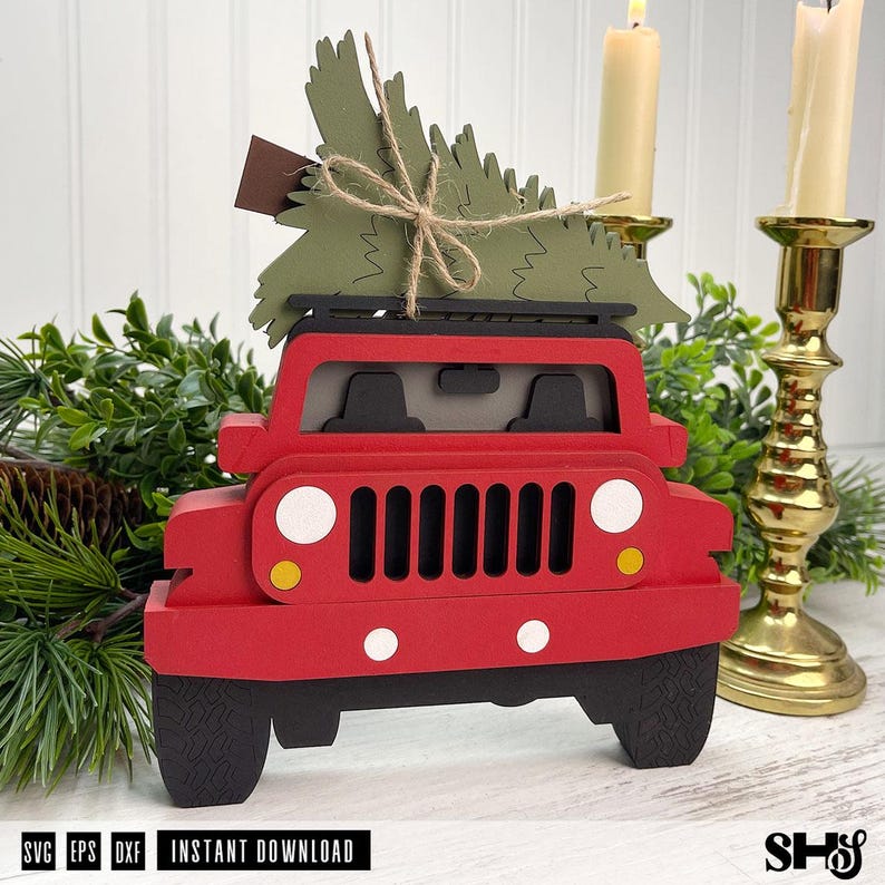 Puede incluir: Una decoraci&oacute;n de cami&oacute;n de juguete rojo en capas con un &aacute;rbol de Navidad de papel verde atado al techo con cordel. El cami&oacute;n tiene una parrilla negra, faros blancos, luces de giro amarillas y neum&aacute;ticos negros. Texto visible: SVG EPS DXF INSTANT DOWNLOAD.
