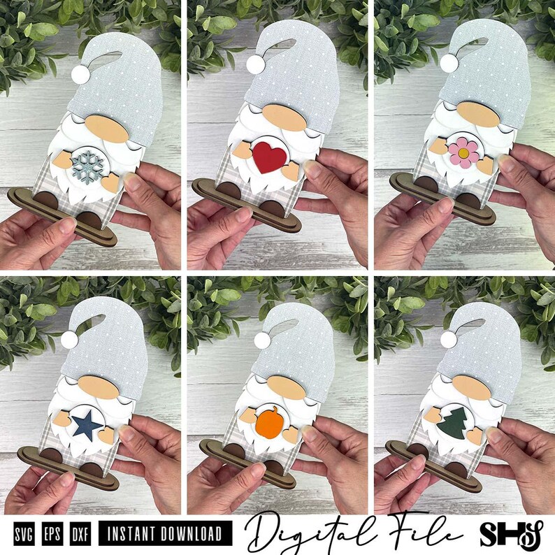 May include: A set of six layered wooden gnome ornaments featuring interchangeable centre icons including a snowflake, red heart, pink flower, blue star, orange pumpkin, and green tree. Each gnome wears a light blue hat with white polka dots.