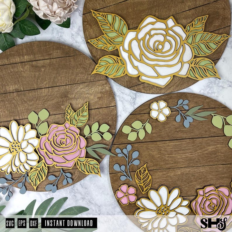 Op de afbeelding: Drie ronde houten borden met bloemmotieven. De borden zijn versierd met witte, roze en gele bloemen en groene bladeren. De borden zijn perfect om een ​​natuurlijke touch aan uw interieur te geven.
