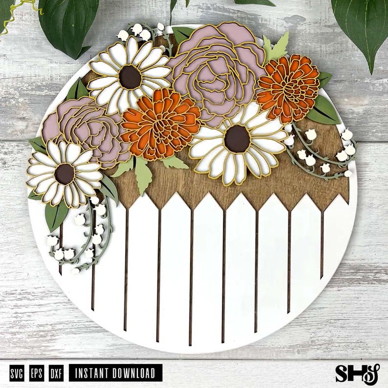 K&ouml;nnte beinhalten: Ein wei&szlig;es rundes Holzschild mit einem braunen Lattenzaun-Design am unteren Rand. Die obere H&auml;lfte des Schildes zeigt eine Blumenarrangements aus wei&szlig;en, rosa und orangefarbenen Blumen mit gr&uuml;nen Bl&auml;ttern.