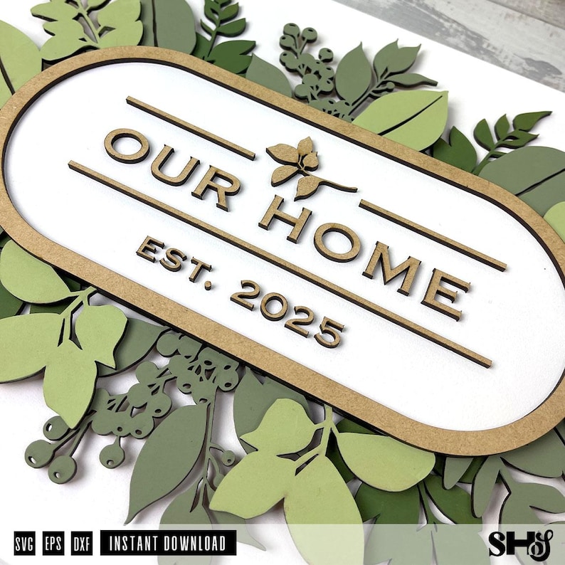 May include: A wooden sign with the text "Our Home Est. 2025" surrounded by green leaves.