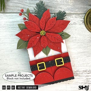 May include: A layered paper craft decoration featuring a large red poinsettia flower with green leaves and red berries at the top. Below the floral arrangement is a red Santa suit design with a black belt, yellow buckles, and white trim.