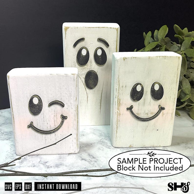 May include: Three rectangular white wooden blocks featuring black ghost faces. One block shows a winking face with a smile, another a surprised face with an open mouth, and the third a smiling face. Text on the image reads: SAMPLE PROJECT Block Not Included.