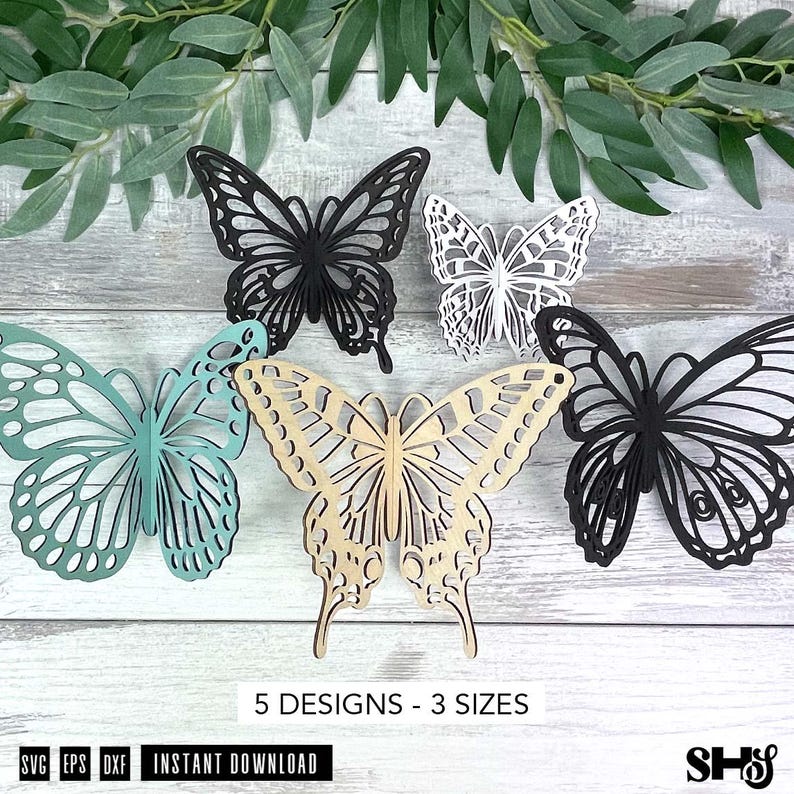 May include: Five butterfly cutouts in various colors including black, white, light blue, and natural wood. Each butterfly features intricate, symmetrical wing patterns with openwork details. The text 5 DESIGNS - 3 SIZES is printed below.