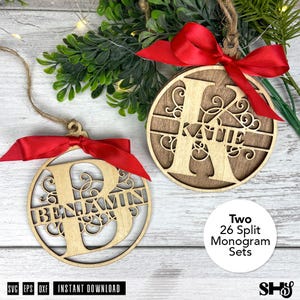 Op de afbeelding: Twee houten kerstversieringen met rode linten. Eén ornament heeft de naam "Benjamin" en de letter "B", de andere heeft de naam "Katie" en de letter "K". De ornamenten zijn rond met een decoratief ontwerp. De tekst "Two 26 Split Monogram Sets" is ook zichtbaar.
