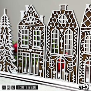 May include: A laser-cut wooden decorative set featuring a stylized evergreen tree and two intricate gingerbread-style houses with white filigree detailing on a dark brown base, designed as a digital file for instant download in SVG, EPS, and DXF formats.